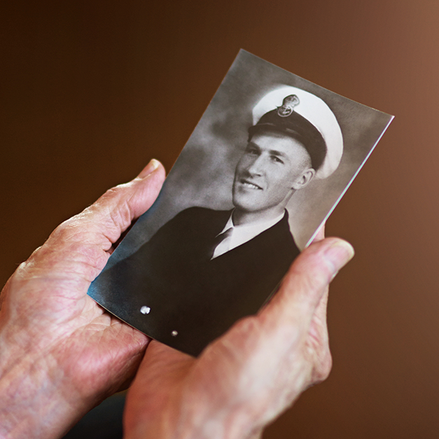 Old hands holding an old photo